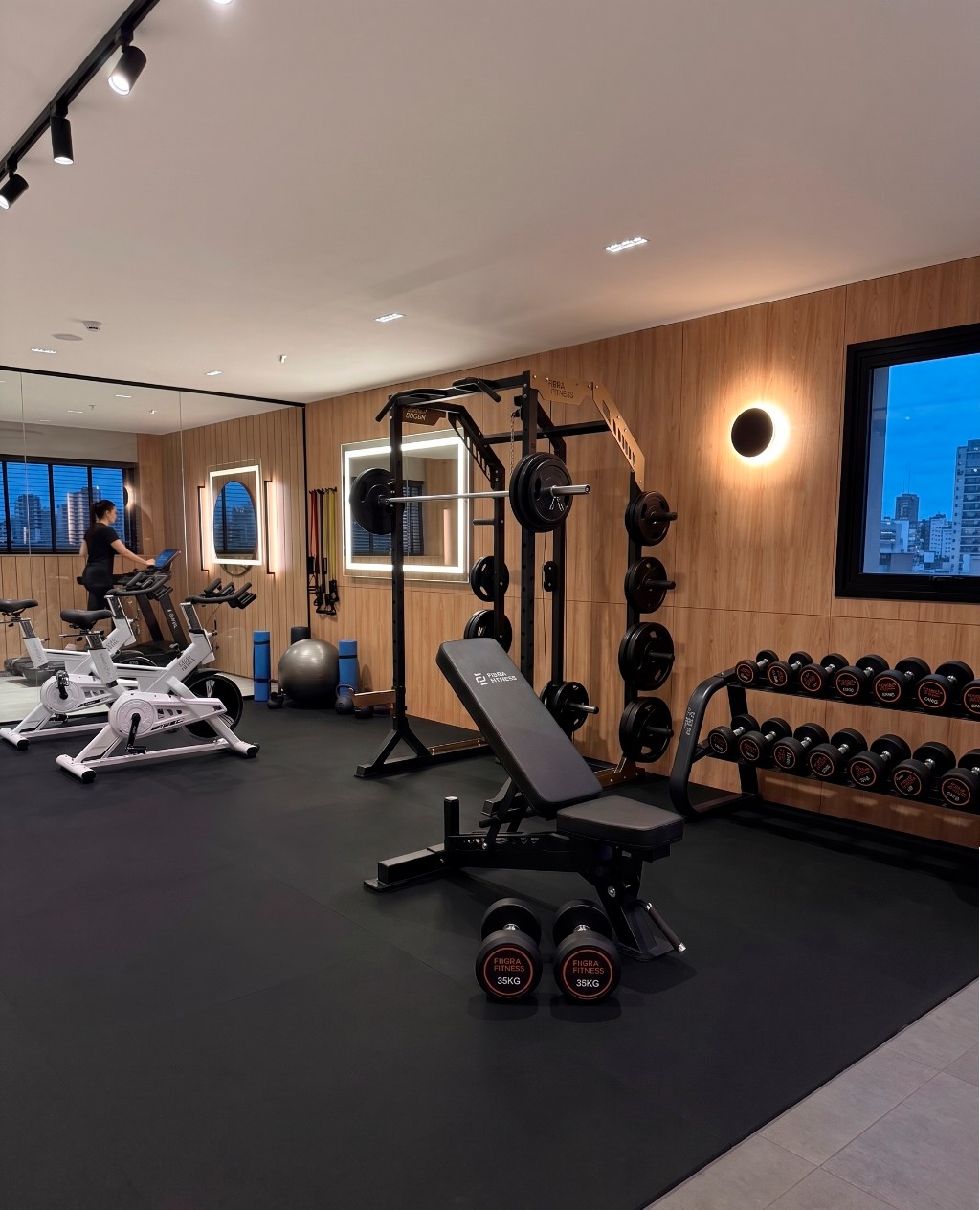 Gimnasio completo de edificio con rack multifunción, banco regulable y zona de cardio en CABA