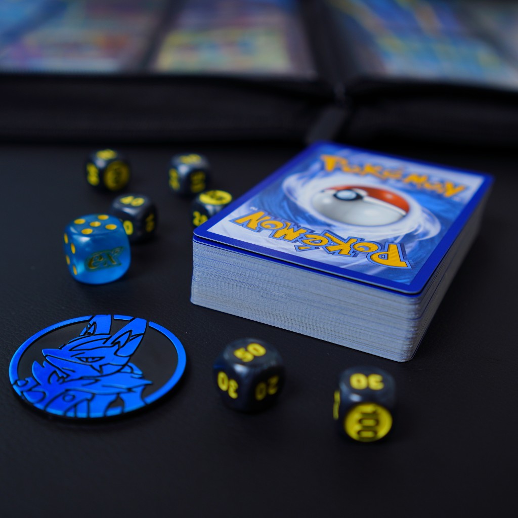 Baralho e acess&oacute;rios de jogo Pok&eacute;mon TCG e binder de cole&ccedil;&atilde;o ao fundo