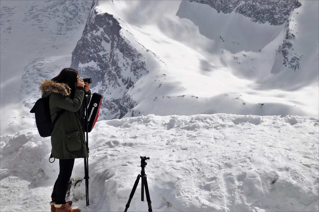 Una joven fotografa realiza una sesi&oacute;n de fotos en la monta&ntilde;a.