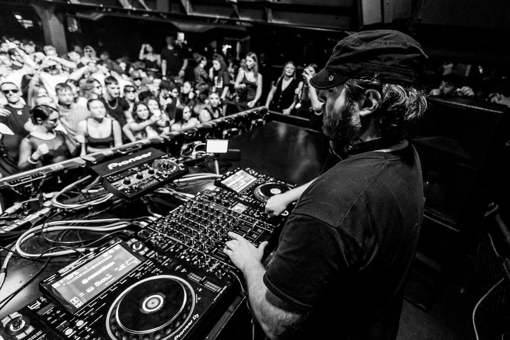 Im&aacute;gen en blanco y negro de un DJ pasando m&uacute;sica en una fiesta.