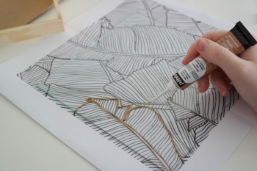 Aplica&ccedil;&atilde;o de contornos dourados com Cerne Relief sobre um desenho de folhas.