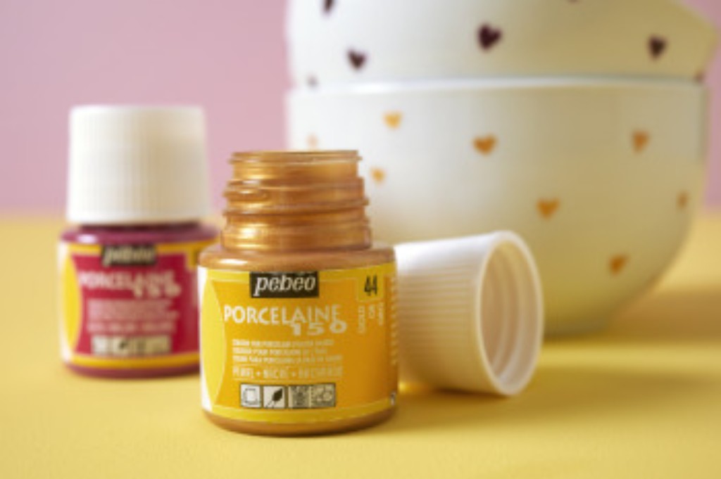 Frascos P&eacute;b&eacute;o Porcelaine 150, com tinta dourada em primeiro plano.