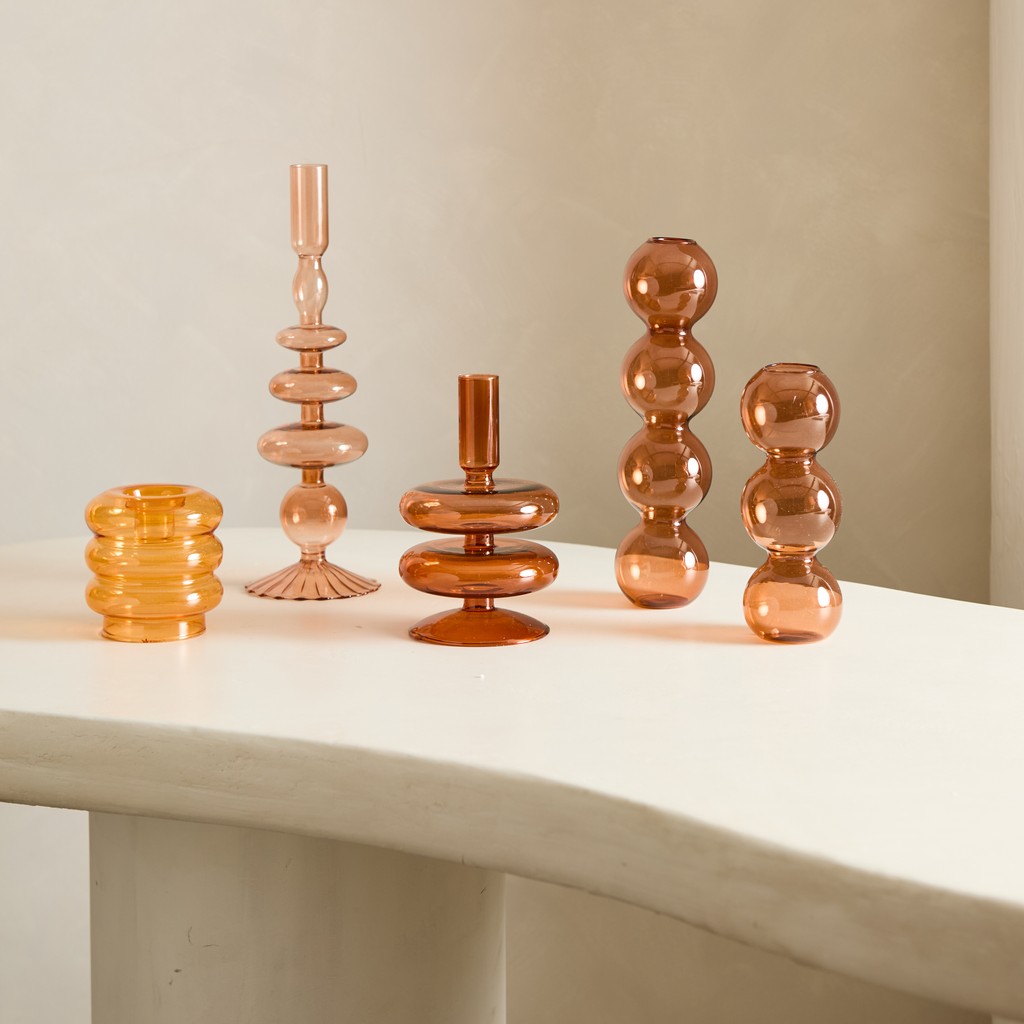 Trío de candelabros de vidrio en tonos ámbar a distintas alturas