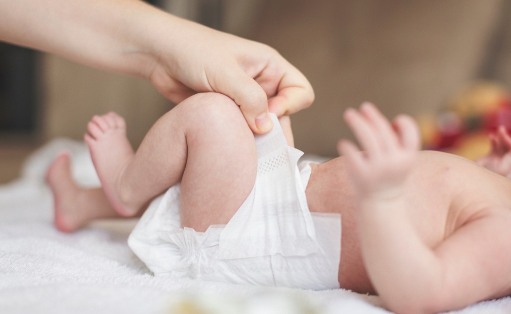 Troca de fraldas de bebê com toque suave e cuidado delicado