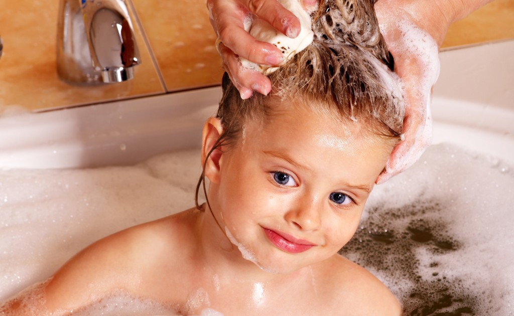 Cabelo infantil sendo lavado com cuidado durante o banho