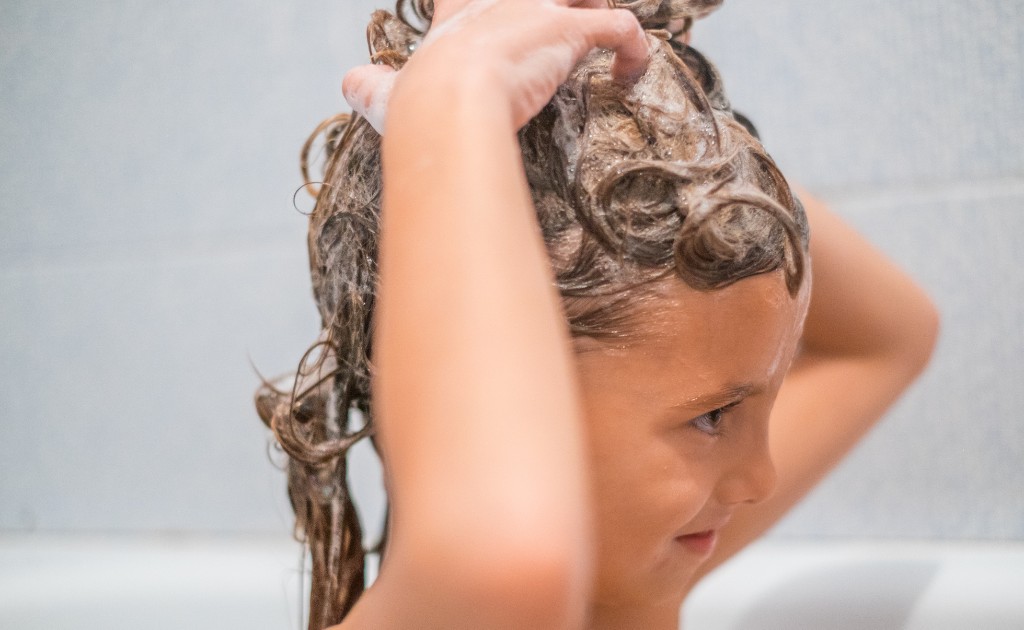 Cabelo cacheado infantil sendo lavado com espuma suave