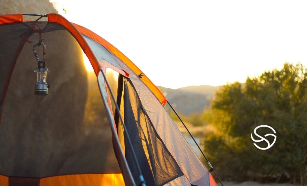 Barraca de camping moderna com estrutura resistente em ambiente natural, representando camping inteligente com conforto e autonomia.