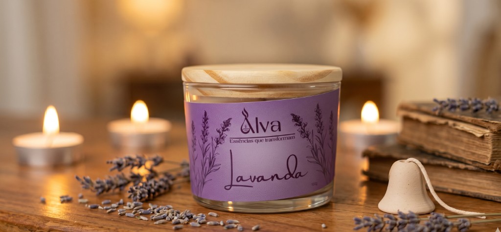 Vela arom&aacute;tica premium da Alva Ess&ecirc;ncias feita com cera de coco vegetal acesa sobre uma mesa de madeira decorada com rodelas de lim&atilde;o siciliano.