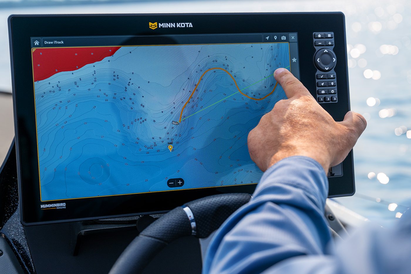 Pescador controlando o motor elétrico Minn Kota pelo pedal na proa do barco