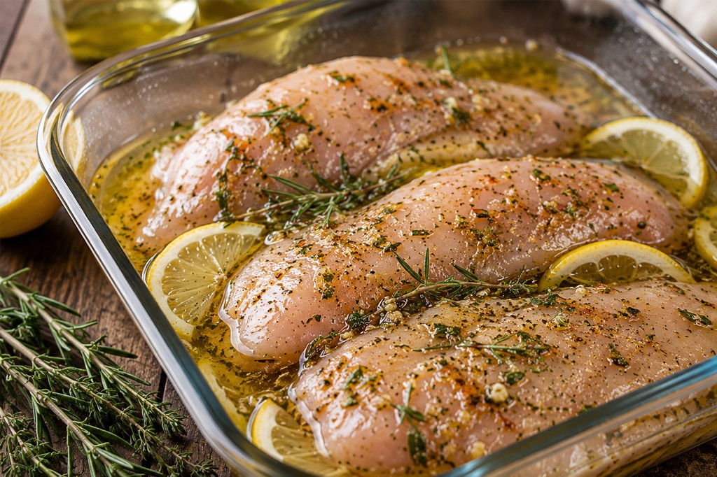 peito de frango marinando com ervas, limão e especiarias