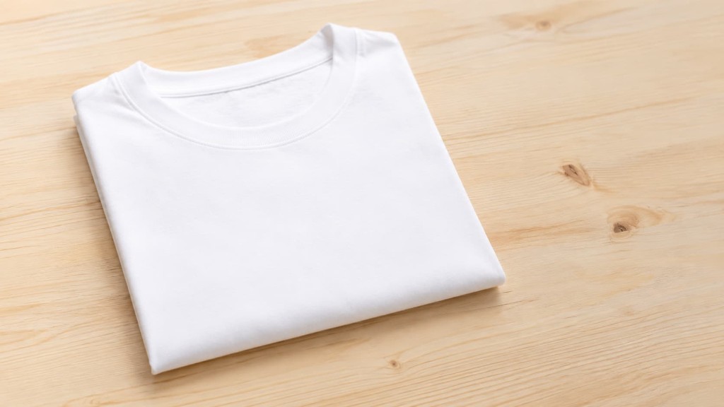 Remera blanca bien cuidada y prolijamente doblada sobre superficie de madera