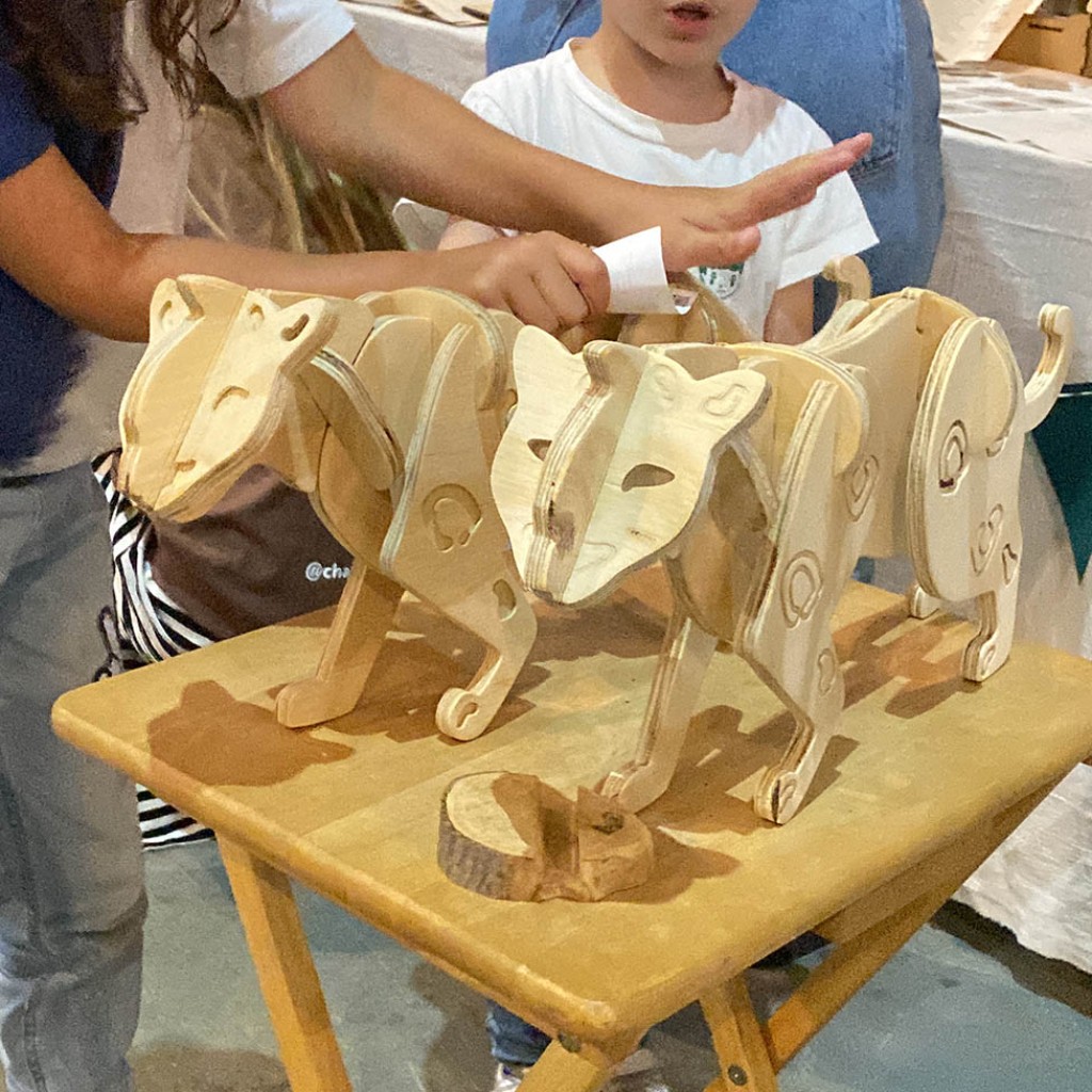 Dos ni&ntilde;os juegan concentrados interactuando con el prototipo del Yaguaret&eacute;, un puzzle tridimensional encastrable de madera natural de Chaj&aacute; Tienda L&uacute;dica, dise&ntilde;ado como una herramienta l&uacute;dica y educativa para generar conciencia sobre el estado de peligro cr&iacute;tico de extinci&oacute;n de este monumento natural de Argentina