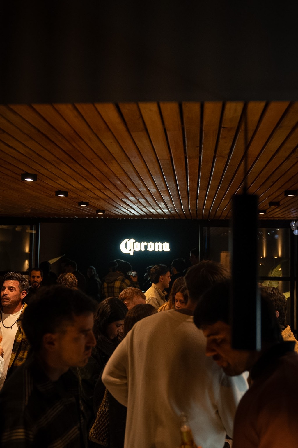 Gente frente al cartel de Corona en las Sesiones Fondiatteras