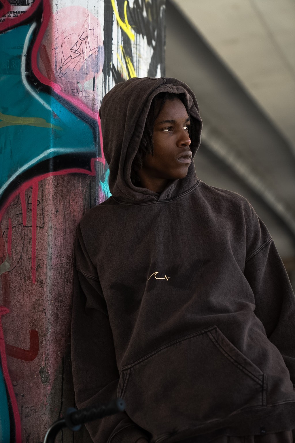 Retrato con el hoodie Plywood contra la columna