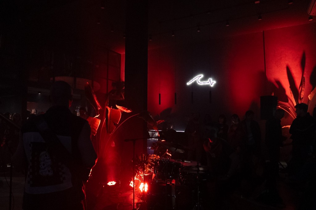 La banda tocando en vivo bajo el logo de Underwave