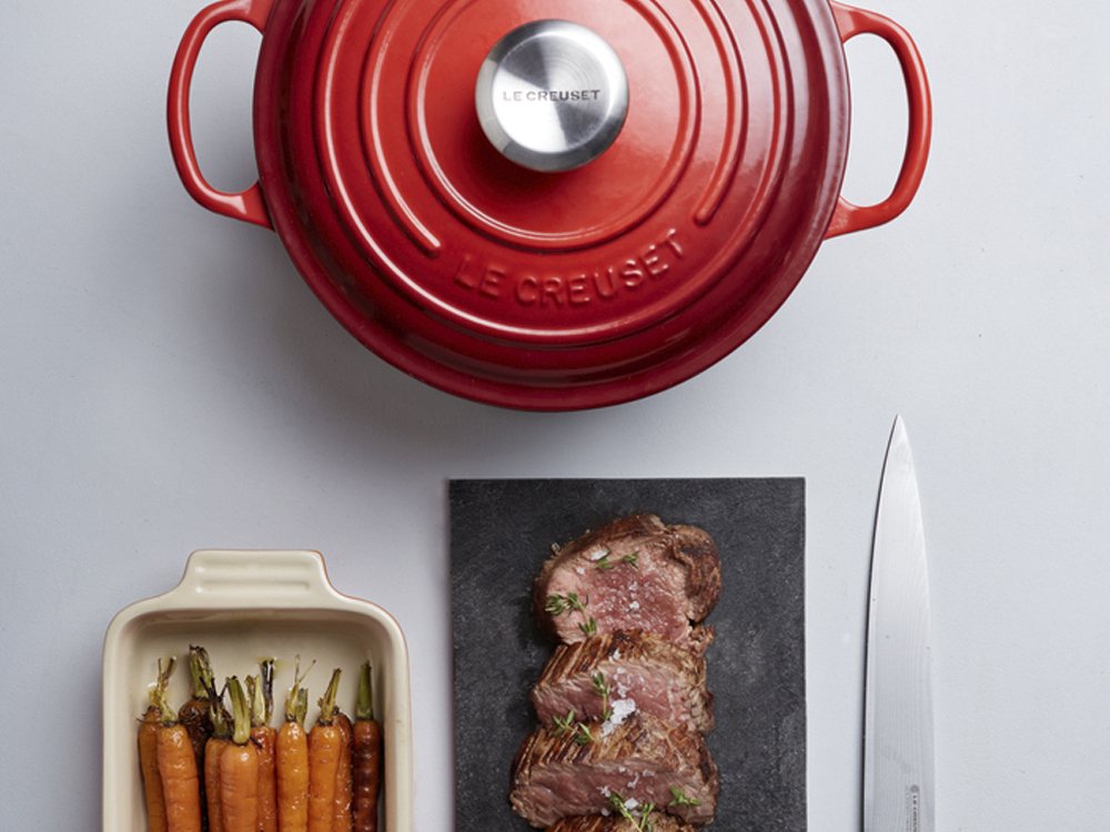 Panela redonda Le Creuset vermelha com carne e cenouras assadas
