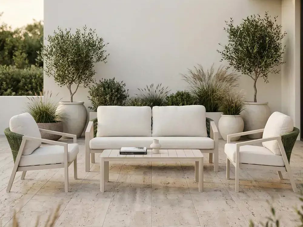 Conjunto Shell com sofá, duas poltronas e mesa de centro num pátio com oliveiras