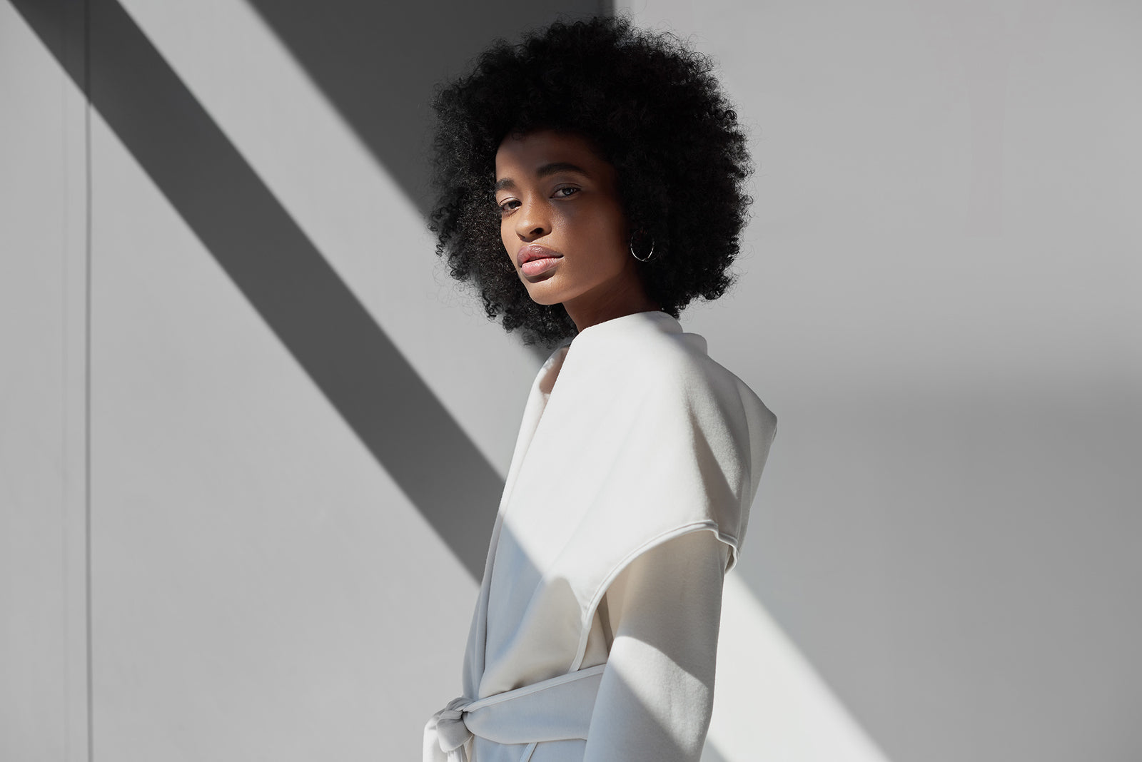 Modelo vestindo um casaco oversized branco da AMARO