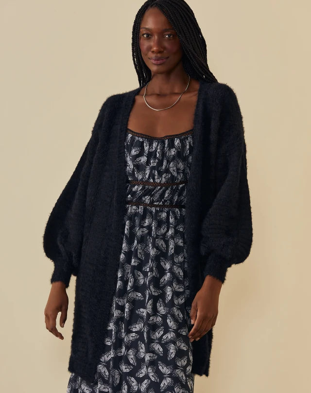 Modelo usando look com cardigan preto de pelinho 
