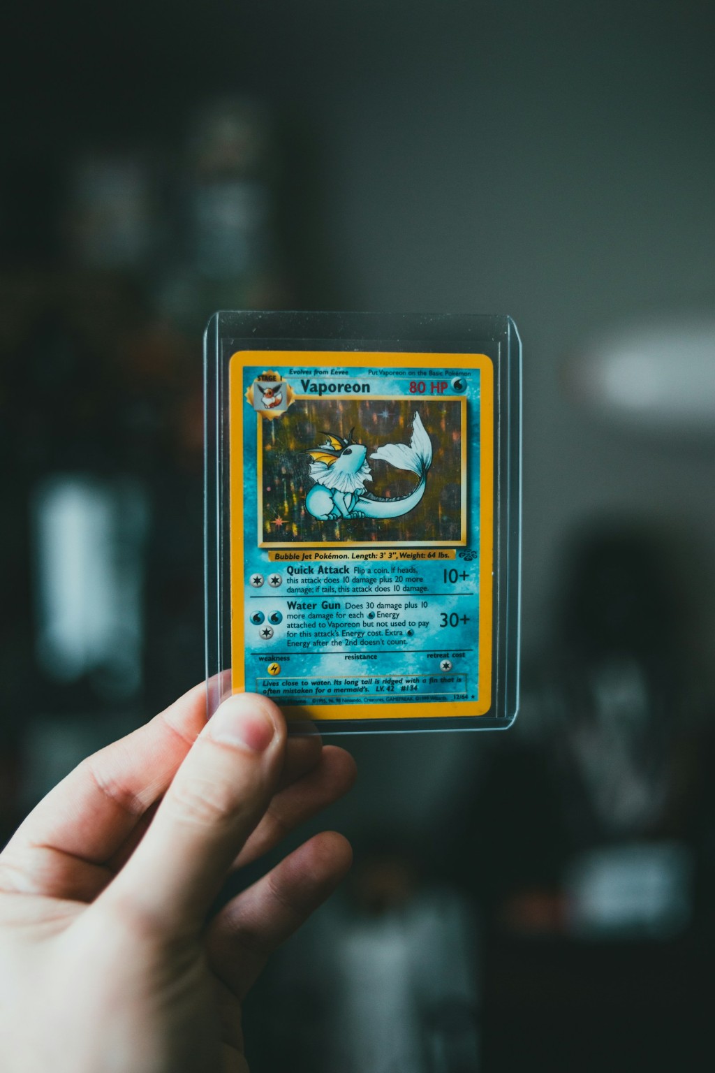 Carta Pok&eacute;mon hologr&aacute;fica inclinada contra a luz